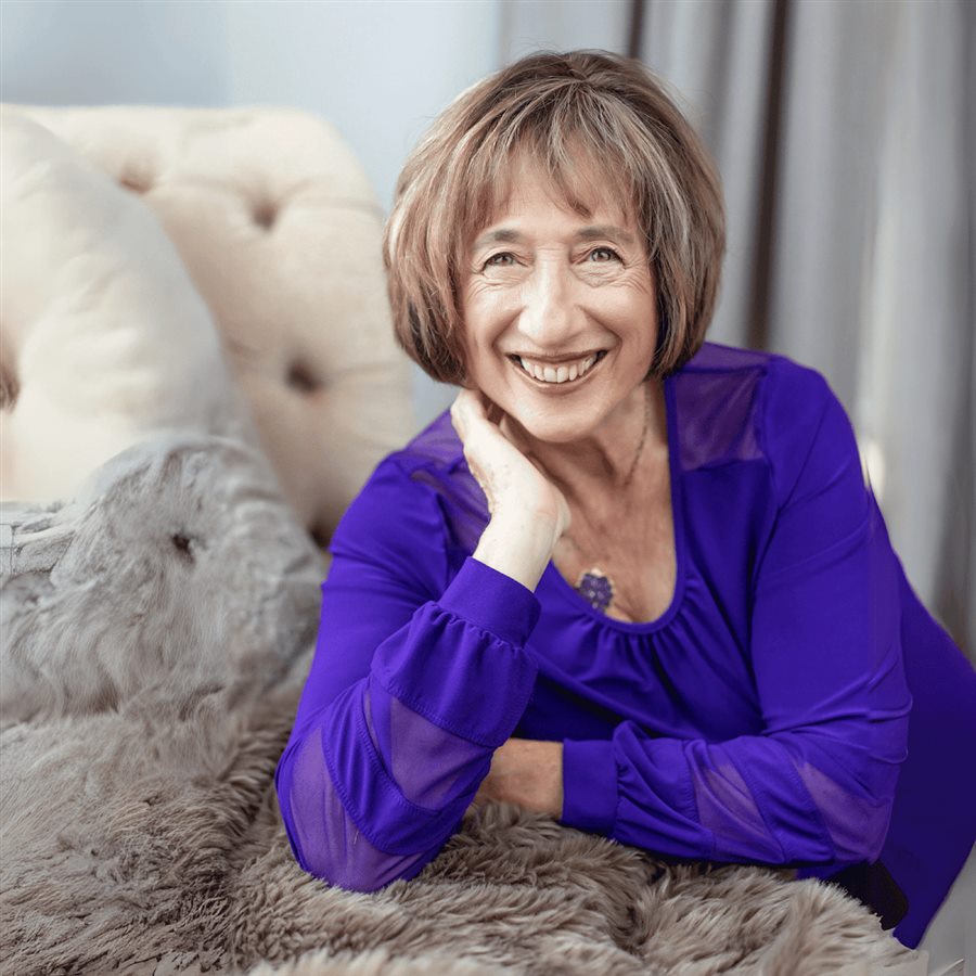 Sue Wiebe, Amazing Psychic Sue, smiling in a purple blouse